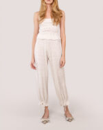 Woman in a Cashmere Heart Knit Camisole in Cream and matching pants with satin ribbon bows at the ankles, wearing bronze pointed-toe flats.
