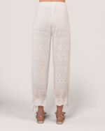 A woman shown from the back wearing Cashmere Heart Knit Pants in Cream, featuring satin ribbon bows at the cuffs.