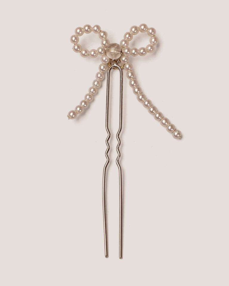 The Pearl Bow Hairpin features a delicate pearl bow design and one iridescent bead in the center, set on a light background.