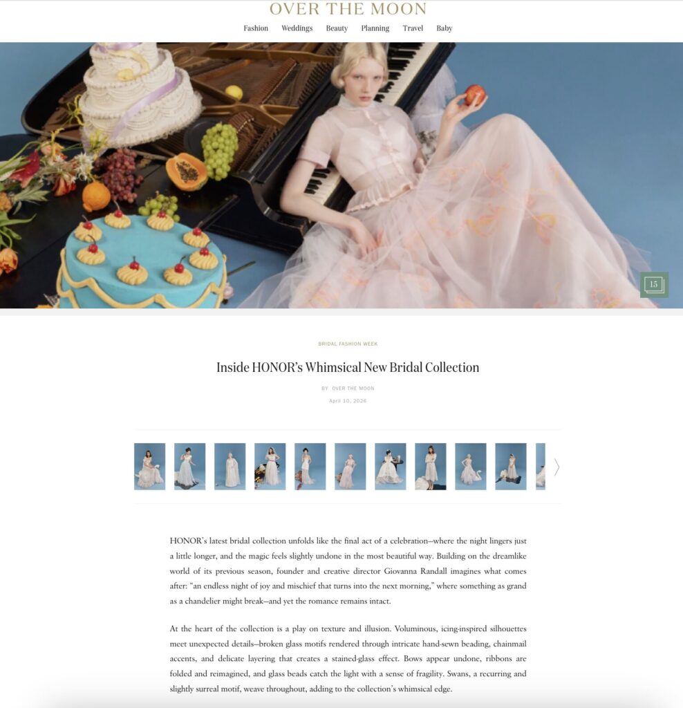 Woman in a sheer pink gown leans against a piano, featured in an Over The Moon Bridal Fashion Week article.